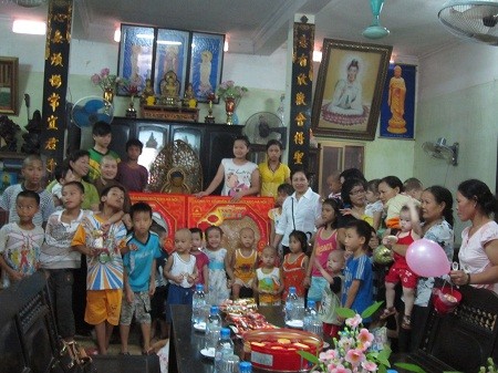 Trụ trì Thích Đàm Lan cùng các em chụp ảnh kỷ niệm với đại diện quỹ bảo trợ trẻ em quận Long Biên.